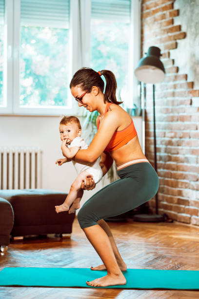 istock Woman exercising at home with baby 1281413904