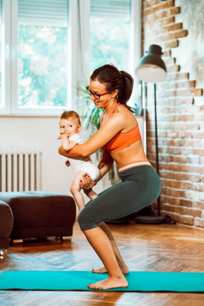 istock Woman exercising at home with baby 1281414017