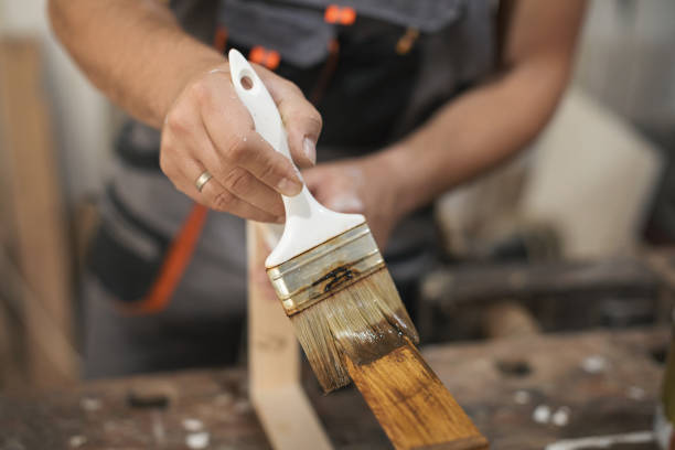 istock Father and daughter painting wooden frame in workshop 1281416353