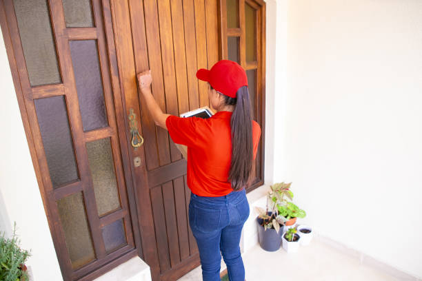 istock Latin courier knocking on door, holding tablet and carton boxes 1281416708