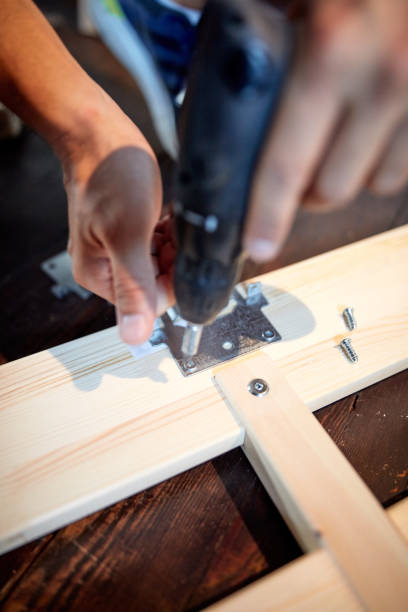 istock Carpenter hobbyist assembling wooden boards at home / garage. 1281416737