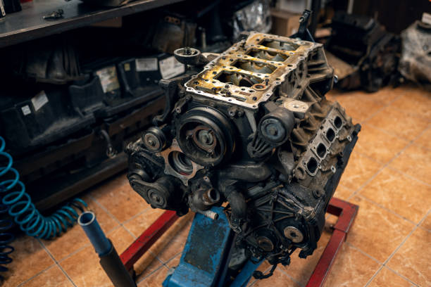 Replacement engine used on a pallet mounted under raised car on lift  for installation after a breakdown and repair in a vehicle workshop as a guarantee for the dealership. Auto service industry.
