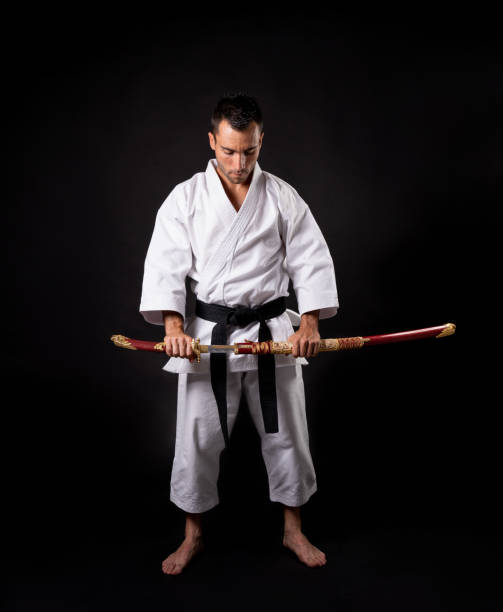 istock karateka practicing kata with with a katana and black background 1281419544