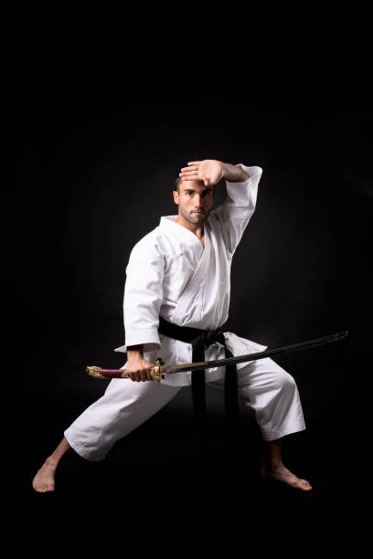 istock karateka practicing kata with with a katana and black background 1281419545