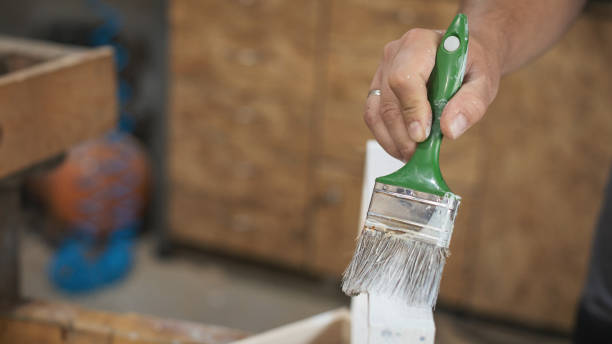 istock Father and daughter painting wooden frame in workshop 1281420261