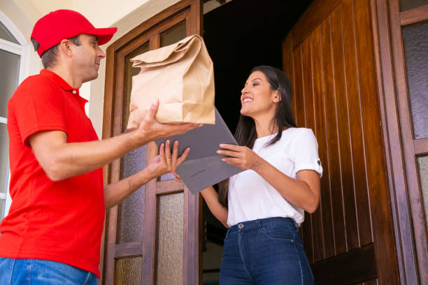 istock Young female receiving paper bag from courier and smiling 1281421993