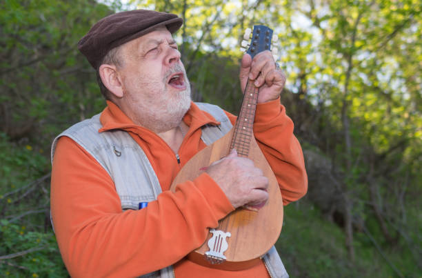 istock Portrait of Caucasian senior man playing mandolin while singing 1281422167