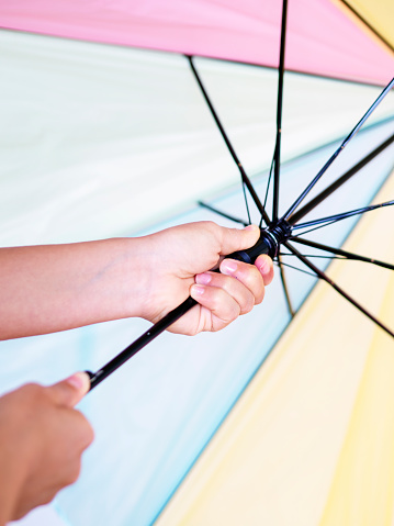 Young woman and a colorful umbrella on gray background