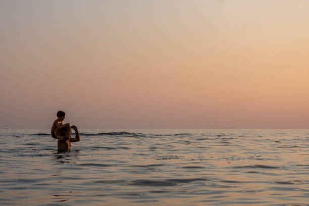 istock The father throws his son into the sea by his shoulder 1281423953