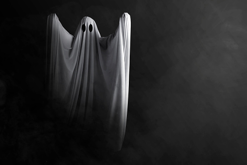 White ghost haunting with a dark background. Halloween concept