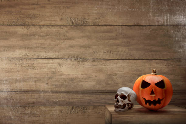 istock Jack-o-Lantern and human skull on the table 1281425533
