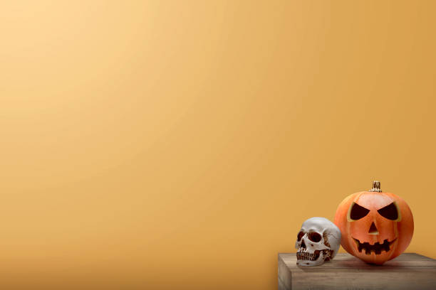 istock Jack-o-Lantern and human skull on the table 1281426407
