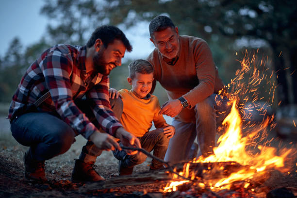 istock Father, son and grandson lit up a campfire in the forest 1281426495