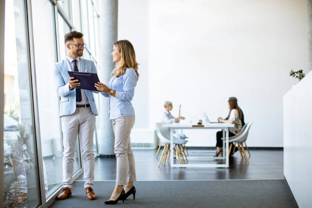 istock Two business people looking a file in a modern office 1281432682