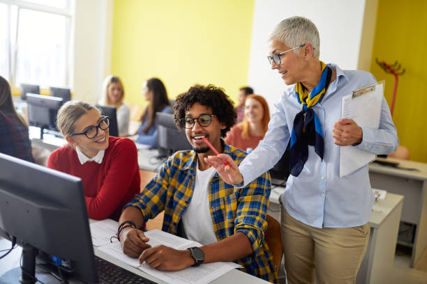 istock A female professor giving help to students at the informatics lecture. Smart young people study at the college. Education, college, university, learning and multiethnic people concept 1281432972