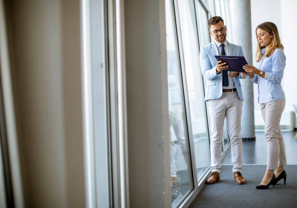istock Two business people looking a file in a modern office 1281434318
