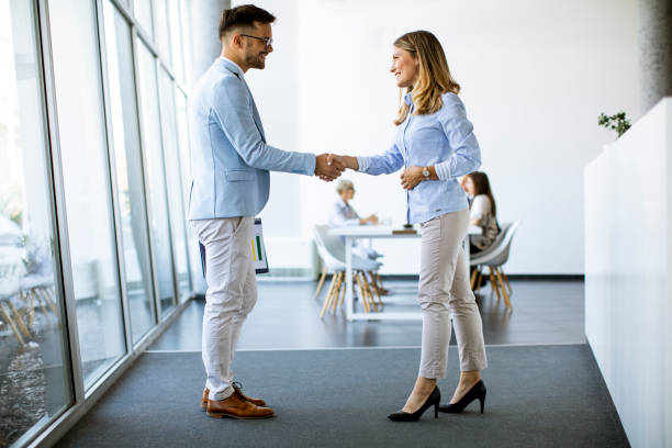 istock Young business partners making handshake in an office 1281434334