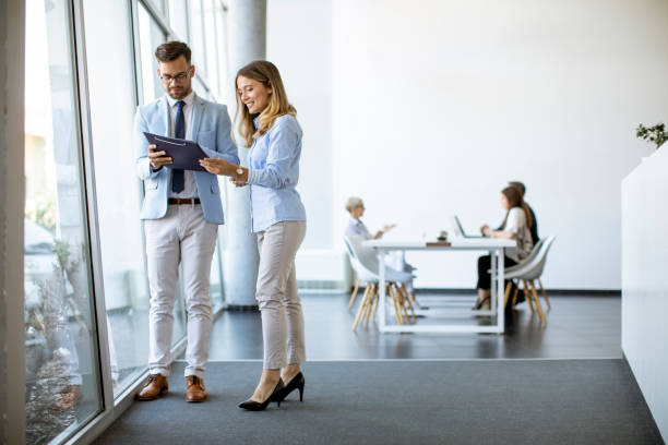 istock Two business people looking a file in a modern office 1281434344