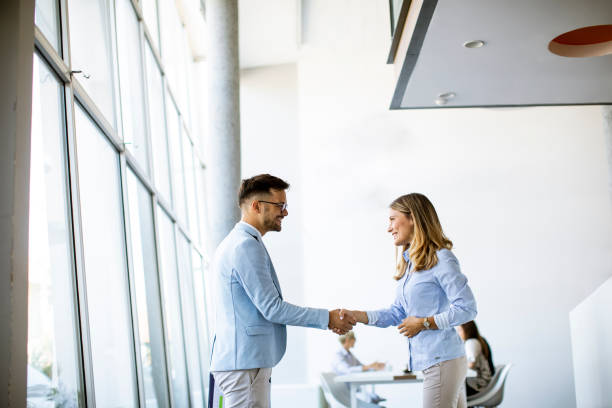 istock Young business partners making handshake in an office 1281434351