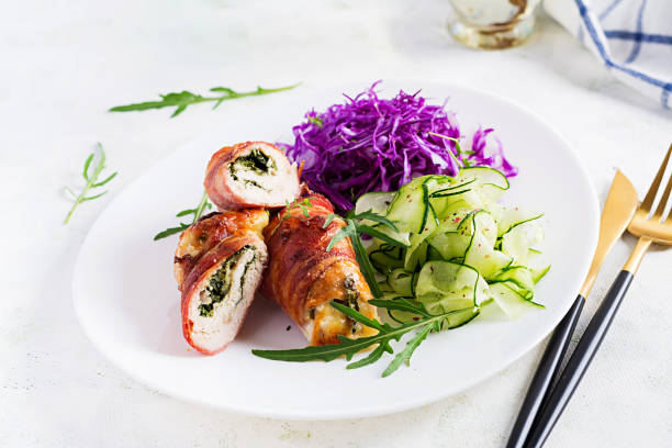 istock Ketogenic diet. Dinner dish with chicken meat roll wish  bacon and salad wich red cabbage, cucumber, arugula. Detox and healthy concept. Keto food. 1281434436