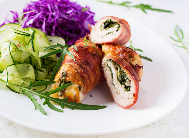 istock Ketogenic diet. Dinner dish with chicken meat roll wish  bacon and salad wich red cabbage, cucumber, arugula. Detox and healthy concept. Keto food. 1281434451