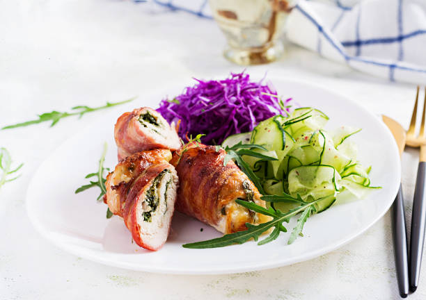 istock Ketogenic diet. Dinner dish with chicken meat roll wish  bacon and salad wich red cabbage, cucumber, arugula. Detox and healthy concept. Keto food. 1281434460