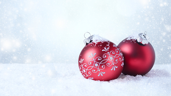 Silver christmas ball with ribbon over snow background, with copy space.
