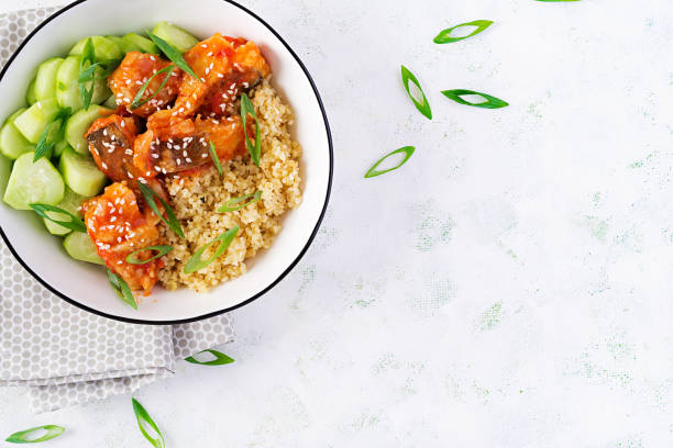 istock Fish fillet cooked in tomato sauce with bulgur and cucumber on a plate on a light background. Healthy eating concept. Easy cooking. Top view, flat lay, copy space 1281435450