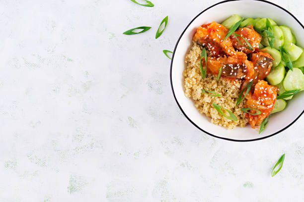 istock Fish fillet cooked in tomato sauce with bulgur and cucumber on a plate on a light background. Healthy eating concept. Easy cooking. Top view, flat lay, copy space 1281435461
