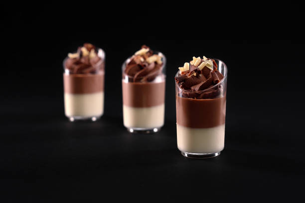 istock Glasses with layered panna cotta mousse isolated on black. 1281436088