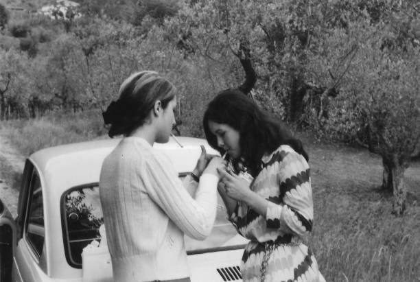 1970s portrait extérieur de jeunes amis s’amusant dans la campagne en noir et blanc. fiat 500 - 1970s style women hippie retro revival photos et images de collection