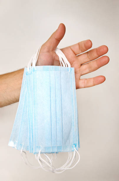 istock male hand holding several disposable medical masks 1281437196