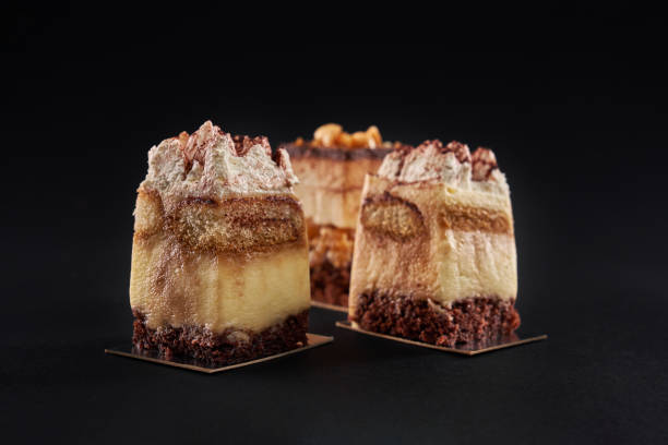 istock Three tiramisu pieces isolated on black background. 1281439767