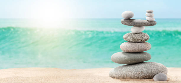 istock Pyramid of sea pebbles on a sunny sand beach 1281440054