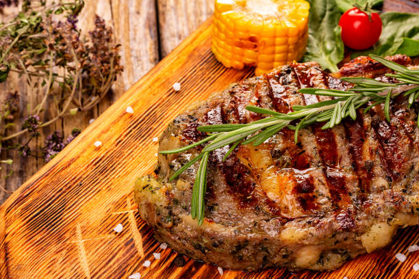 istock Juicy medium rare beef steak on wooden board with herbs. 1281445538