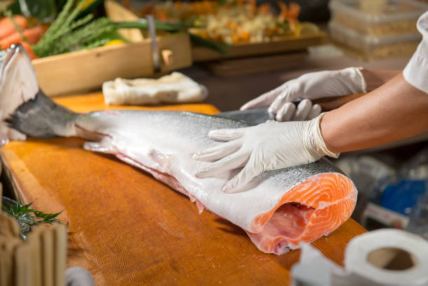 istock Sushi Chef is cutting salmon on wooden board 1281446079