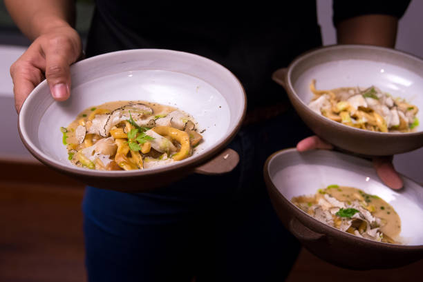 istock Waiter serve yellow spaghetti with black truffle with busy hand 1281446096