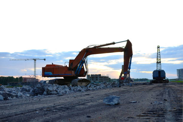 istock Excavator with hydraulic shears breaks asphalt on a construction site 1281449681