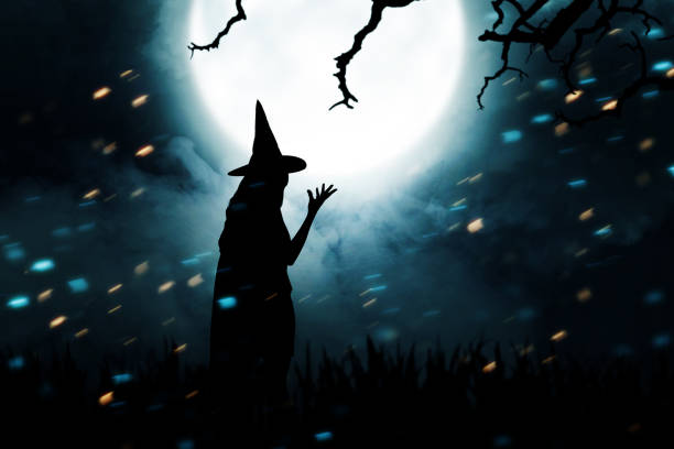 istock Silhouette of witch woman with a hat standing 1281451370