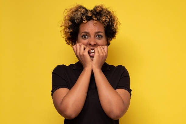 istock Beautiful young african woman biting her nails, being afraid or feeling nervous 1281451597