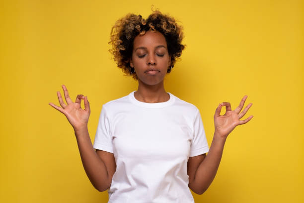 istock Beautiful african woman keeping eyes closed while practicing yoga meditating, holding hands in mudra gesture. 1281451798