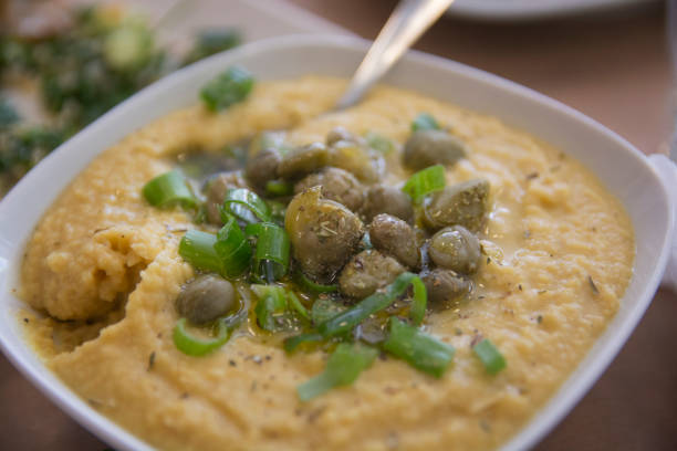 A bowl of traditional Greek Fava - Puree of Yellow split peas, served with Capers and scallion stock photo
