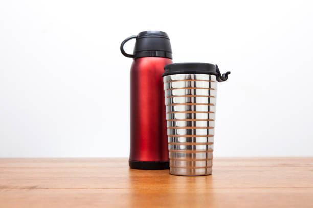 Metallic red coloured vacuum flask behind a 345ml or 12 fl oz size silver coloured insulated drink container