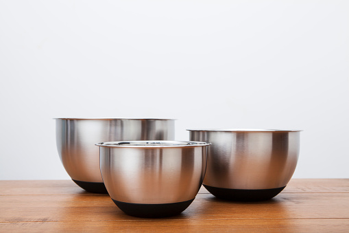 Three different sized silver coloured kitchen mixing bowls