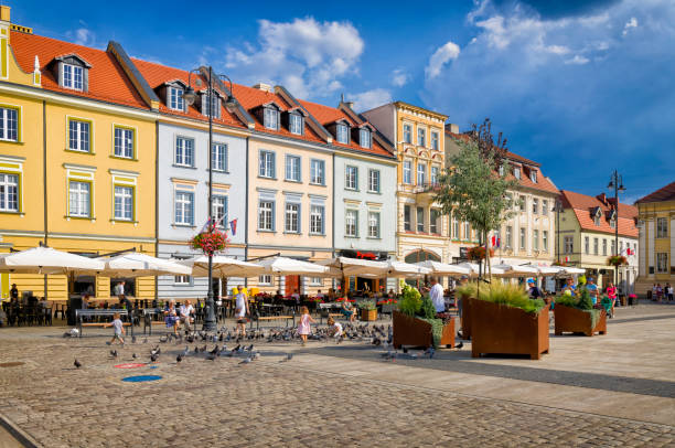 Bydgoszcz, Poland - August,15,2020:View of the market square in the old town of Bydgoszcz. A flock of pigeons, cafes, restaurants, beer gardens and old historic tenement houses