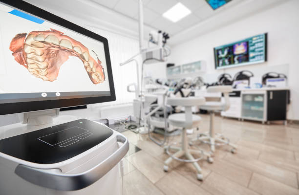 Modern dental office, equipped with computers and high precision technologies Snapshot of empty clean dental office. Interior of modern dental clinic. Computer screen with high precision digital jaw print on it on foreground. monitoring equipment photos stock pictures, royalty-free photos & images