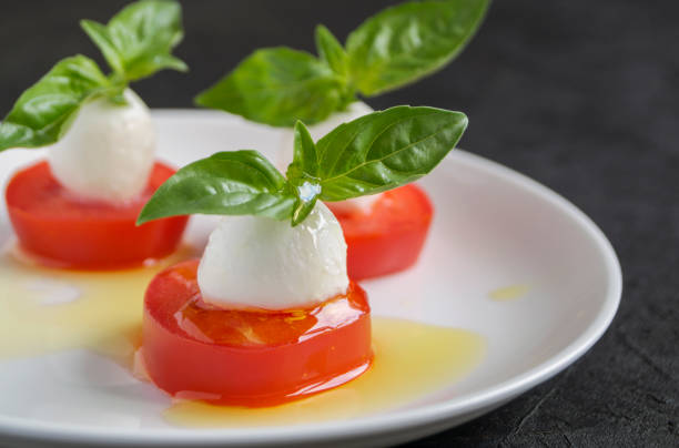 istock Caprese salad with ripe tomatoes and mozzarella with fresh Basil leaves. 1281463488