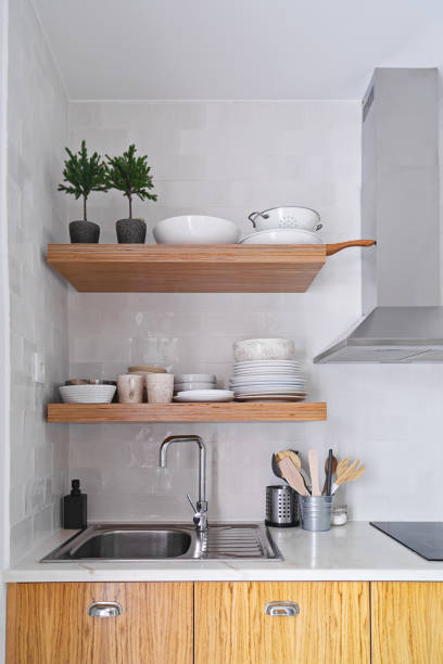 istock Wooden kitchen shelves with tableware on white ceramic tile wall in Scandinavian style 1281463662