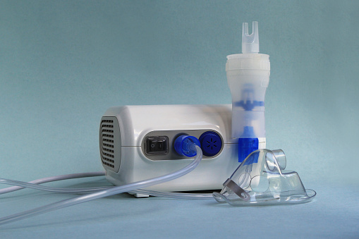 Nebulizer medical equipment on blue background.