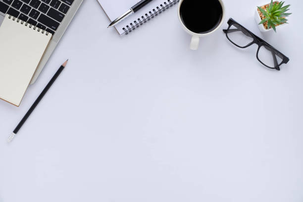 istock Top view above of White office desk table with keyboard, notebook and coffee cup with equipment other office supplies. Business and finance concept. Workplace, Flat lay with blank copy space. 1281464773